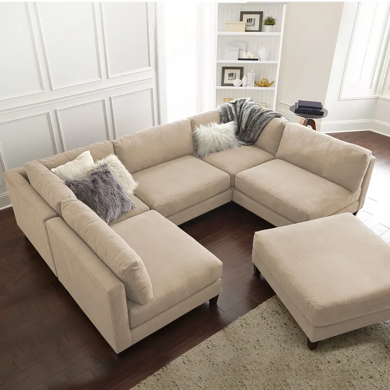 A sectional couch adorned with decorative pillows and accompanied by matching ottomans in a cozy living room setting